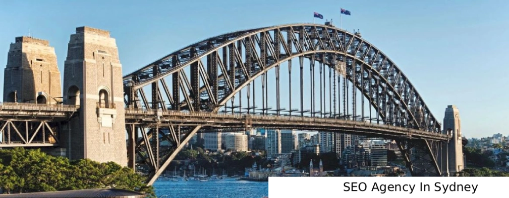 SEO Agency In Sydney view of the Sydney Harbour Bridge arching over the water under a blue sky, with the city skyline visible in the background.